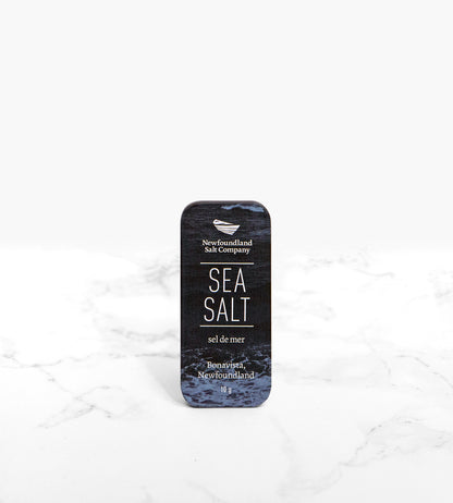 The front of a small tin rectangular tin of sea salt. The tin features a dark blue ocean texture.